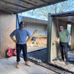 Volunteers working inside the shipping containers on the Slice of Hope build