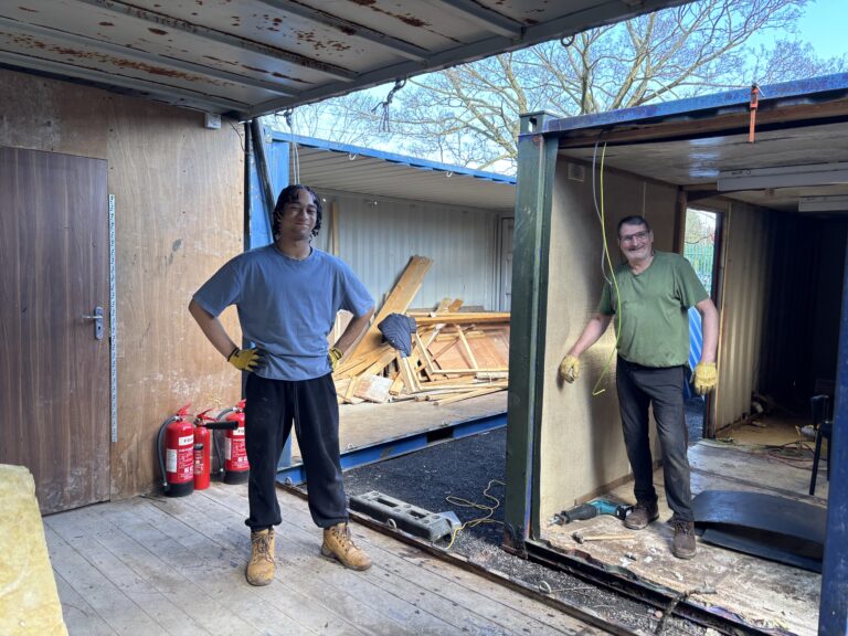 Volunteers working inside the shipping containers on the Slice of Hope build