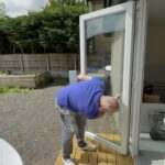 Glass door of a converted container with decking outside, Slice of Hope