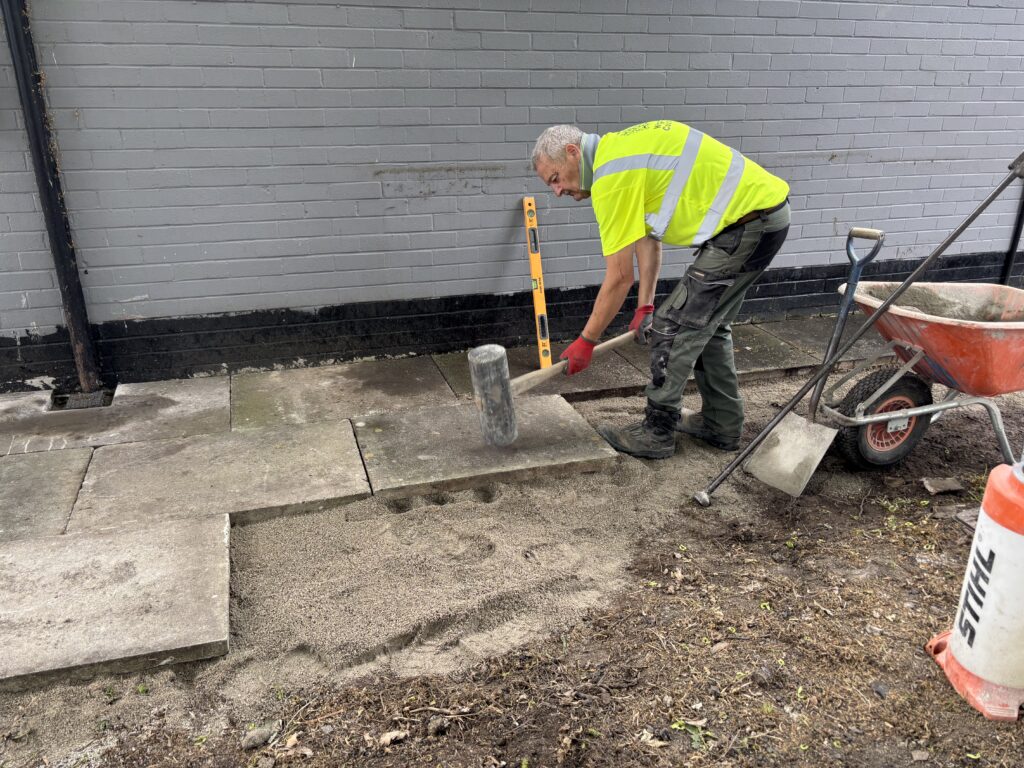 Laying paving slabs for outdoor space at Slice of Hope